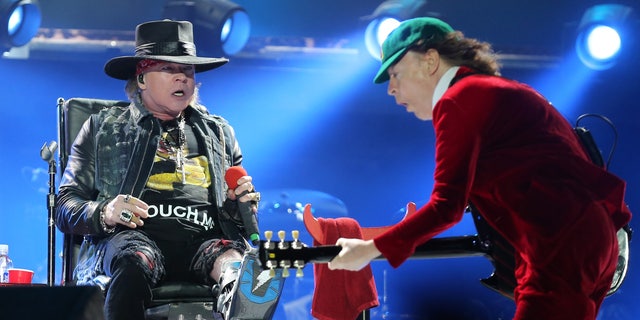 Guns N' Roses singer Axl Rose, left, watches AC/DC lead guitar player Angus Young perform during the concert of Australian rock band AC/DC in Lisbon Saturday night, May 7, 2016.