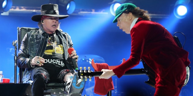 Guns N' Roses singer Axl Rose, left, watches AC/DC lead guitar player Angus Young perform during the concert of Australian rock band AC/DC in Lisbon Saturday night, May 7, 2016.