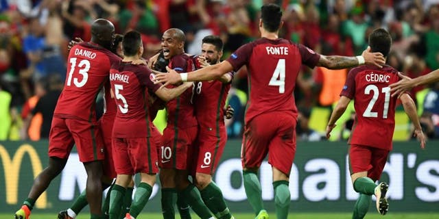 Portugal team players celebrate as they clinch the match 1-0 against France in the Euro 2016 final football match between France and Portugal at the Stade de France in Saint-Denis, north of Paris, on July 10, 2016. / AFP / FRANCK FIFE (Photo credit should read FRANCK FIFE/AFP/Getty Images)