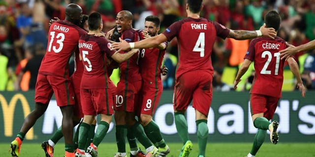 Portugal team players celebrate as they clinch the match 1-0 against France in the Euro 2016 final football match between France and Portugal at the Stade de France in Saint-Denis, north of Paris, on July 10, 2016. / AFP / FRANCK FIFE (Photo credit should read FRANCK FIFE/AFP/Getty Images)