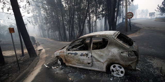 A burned car is seen in the aftermath of a forest fire near Pedrogao Grande, in central Portugal, June 18, 2017.