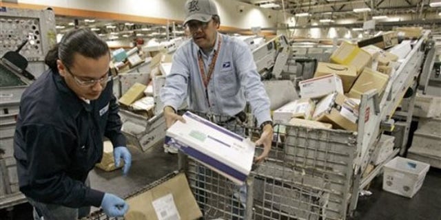 FILE: U.S. Postal Service mail handlers sort packages at the USPS San Francisco center.