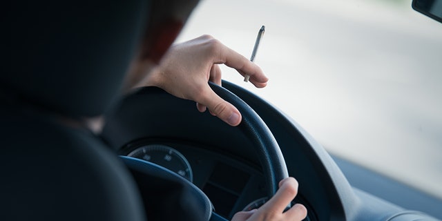 Man driving and smoking joint