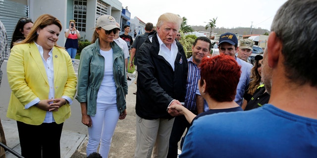 President Trump greeting people while walking through the hurricane-affected areas of a neighborhood in San Juan with first lady Melania Trump on October 3, 2017.