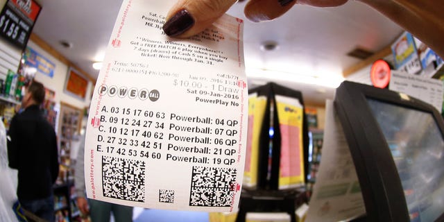 In this photo made with a fisheye lens a clerk hands a patron his $10 worth of chances for the upcoming Powerball drawing on Saturday, Jan. 9, 2016, in Cranberry Township, Pa. The Powerball jackpot has reached a record $900 million, with the drawing Saturday night. (AP Photo/Keith Srakocic)
