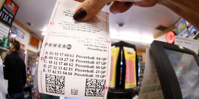 In this photo made with a fisheye lens a clerk hands a patron his $10 worth of chances for the upcoming Powerball drawing on Saturday, Jan. 9, 2016, in Cranberry Township, Pa. The Powerball jackpot has reached a record $900 million, with the drawing Saturday night. (AP Photo/Keith Srakocic)