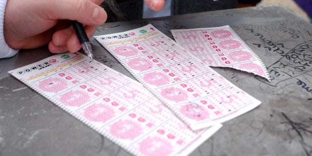 Customers picking numbers on Powerball lottery forms.