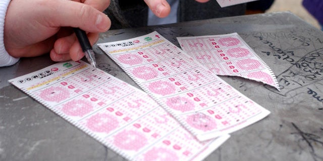 Customers picking numbers on Powerball lottery forms.