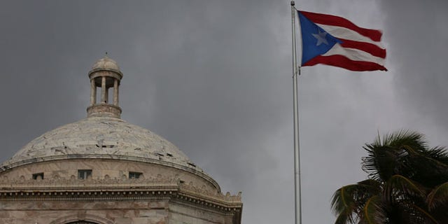 SAN JUAN, PUERTO RICO - JULY 01: The Puerto Rican flag flies near the Capitol building as the island's residents deal with the government's $72 billion debt on July 1, 2015 in San Juan, Puerto Rico. Governor of Puerto Rico Alejandro Garc?a Padilla said in a speech recently that the people of Puerto Rico will have to make sacrifices and share the responsibilities to help pull the island out of debt. (Photo by Joe Raedle/Getty Images)