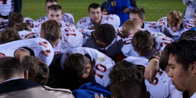 Kennedy praying on the field after the high school's homecoming game.