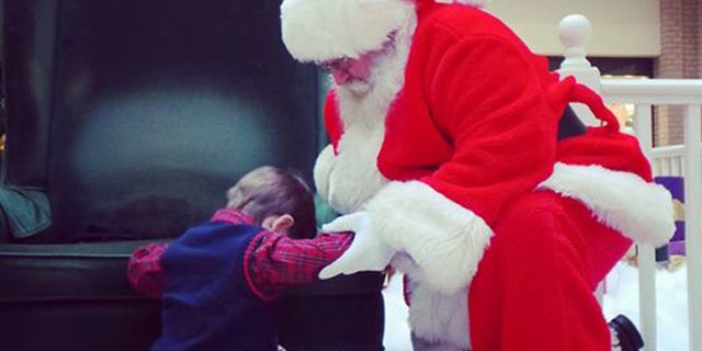Prestyn Barnette, 4, prays for Baby Knox with Santa at South Carolina mall (Rebekah Lauren Sharpe)