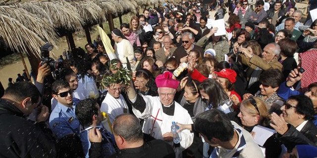 A Christian priest blesses worshippers during a mass at a baptism site on the Jordan River Jan. 14.