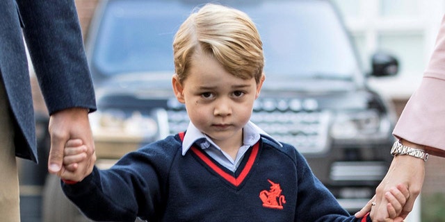 Prince George is seen holding his parents hands outside Kensington Palance in the United Kingdom.