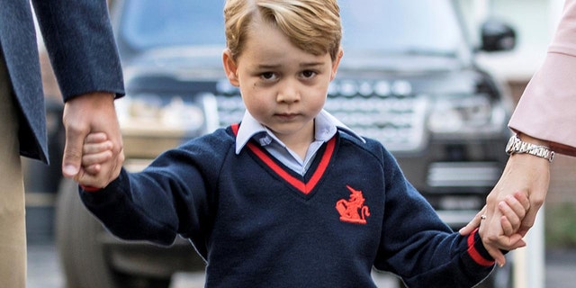 Prince George is seen holding his parents hands outside Kensington Palance in the United Kingdom.