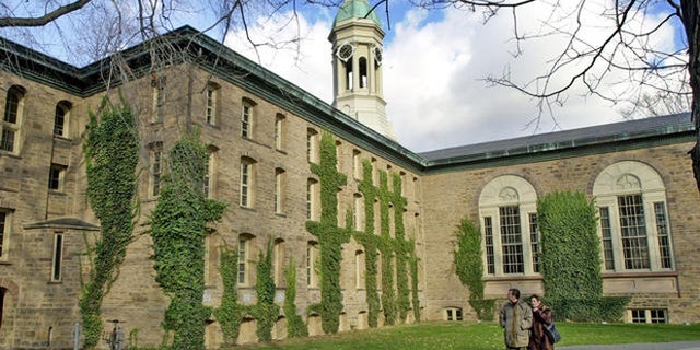 A couple walks past Nassau Hall on the Princeton University campus in Princeton, N.J.