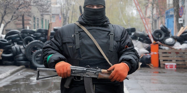 April 13, 2014: A pro-Russian gunman stands guard at a seized police station in the eastern Ukraine town of Slovyansk.