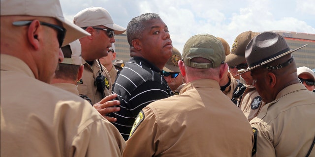 rganizer of an anti-violence protest the Rev. Gregory Livingston, center, is arrested while protesting along a ramp leading on to Interstate 90, known as the Kennedy Expressway, in Chicago, Monday, Sept. 3, 2018.