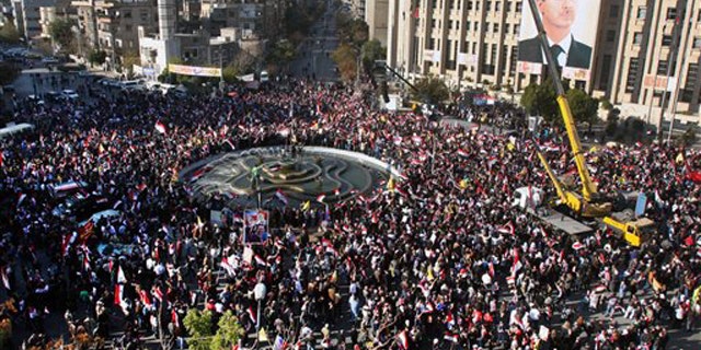 Pro-Syrian regime protesters gather during a protest against sanctions, in Damascus, Syria, on Friday Dec. 2, 2011.