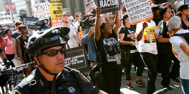 Protesters march in downtown Cleveland, on Tuesday, July 19, 2016, during the second day of the Republican convention. (AP Photo/John Minchillo)