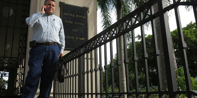 Attorney Santiago Mari talks to a client in front of a federal courthouse in San Juan, Puerto Rico.