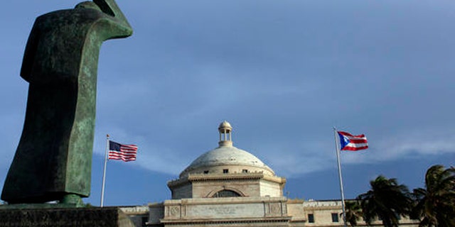 A bronze statue of San Juan Bautista stands in front of Puerto Ricos capitol in San Juan.