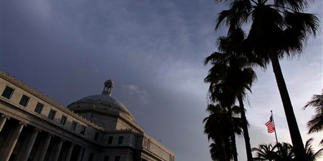 FILE - In this July 29, 2015 file photo, the U.S. flag flies in front of Puerto Ricoâs Capitol in San Juan, Puerto Rico. Plans to create a powerful fiscal control board to help stabilize the U.S. territory's finances and appease bondholders amid an economic crisis have been derailed. On Thursday, Nov. 12, 2015, legislators approved the measure but only after making amendments that strip the board of most of its powers. The Senate will review the amended bill again before it is presented to the islandâs governor. (AP Photo/Ricardo Arduengo, File)