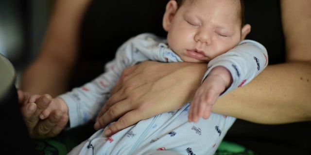 In this Dec. 16, 2016 photo, two-month-old Inti Perez, diagnosed with microcephaly linked to the mosquito-borne Zika virus, is cradled by his mother, in Bayamon, Puerto Rico. The U.S. Centers for Disease Control and Prevention has projected a surge of cases next year. (AP Photo/Carlos Giusti)