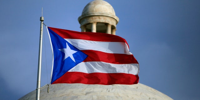 In this July 29, 2015 file photo, the Puerto Rican flag flies in front of Puerto Rico's Capitol as in San Juan, Puerto Rico.