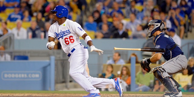 El jugador de los Dodgers de Los Angeles, Yasiel Puig, conecta un sencillo contra los Padres de San Diego en su primer partido en Grandes Ligas el lunes, 3 de junio de 2013, en Los Angeles. (AP Photo/Mark J. Terrill)