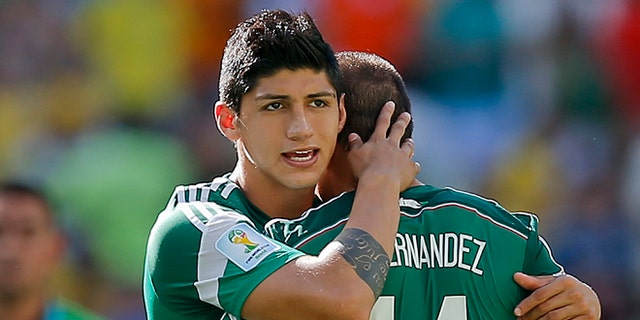 FILE - In a June 29, 2014 file photo, Mexico's Alan Pulido consoles teammate Javier Hernandez (14) after the Netherlands defeated Mexico 2-1 during the World Cup round of 16 soccer match between the Netherlands and Mexico at the Arena Castelao in Fortaleza, Brazil. A state official says that Mexican soccer star Alan Pulido has been kidnapped in the northern border state of Tamaulipas. The official says the 25-year-old player was kidnapped near his hometown of Ciudad Victoria on Sunday after leaving a party. (AP Photo/Eduardo Verdugo, File)
