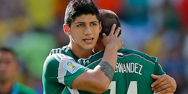 FILE - In a June 29, 2014 file photo, Mexico's Alan Pulido consoles teammate Javier Hernandez (14) after the Netherlands defeated Mexico 2-1 during the World Cup round of 16 soccer match between the Netherlands and Mexico at the Arena Castelao in Fortaleza, Brazil. A state official says that Mexican soccer star Alan Pulido has been kidnapped in the northern border state of Tamaulipas. The official says the 25-year-old player was kidnapped near his hometown of Ciudad Victoria on Sunday after leaving a party. (AP Photo/Eduardo Verdugo, File)
