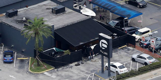 Law enforcement officials work at the Pulse gay nightclub in Orlando, Fla.
