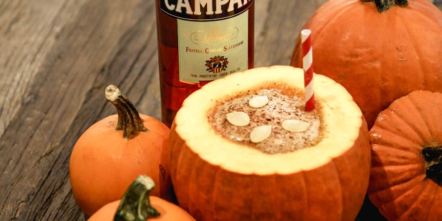 Pumpkin Spice Negroni served in a pumpkin bowl.