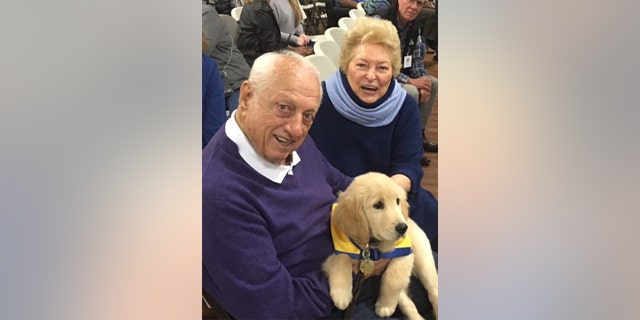 Tommy Lasorda SR (left) with a Canine Companions for Independence puppy in training.