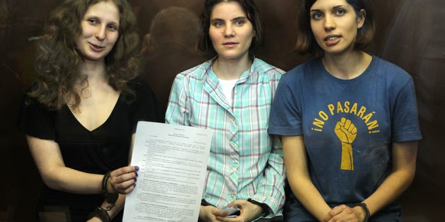 Aug 17, 2012: Feminist punk group Pussy Riot members, from left, Maria Alekhina, Yekaterina Samutsevich, and Nadezhda Tolokonnikova show the court's verdict as they sit in a glass cage at a court room in Moscow, Russia.