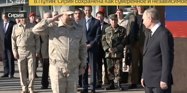 Sergei Surovikin, Russian Commander in Syria, 3rd left, reports to President Vladimir Putin, right, as Syrian President Bashar Assad, 4th left, listens, at the Hemeimeem air base in Syria.
