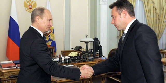 May 18, 2012: Russian President Vladimir Putin shakes hands with Igor Kholmanskikh, right, a section head at the Uralvagonzavod tank factory in the Urals city of Nizhny Tagil that builds battle tanks, in Novo-Ogaryovo residence outside Moscow.