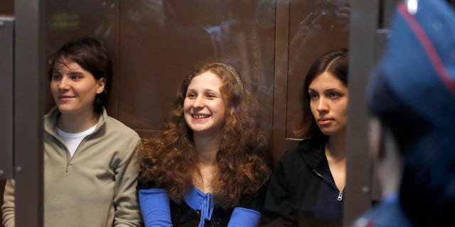 Oct. 10, 2012: Feminist punk group Pussy Riot members, from left, Maria Alekhina, Yekaterina Samutsevich and Nadezhda Tolokonnikova sit in a glass cage at a court room in Moscow.