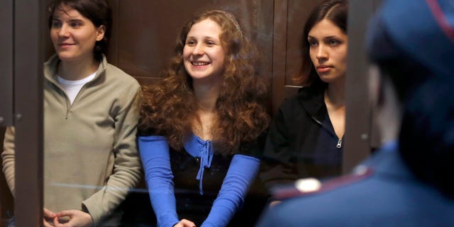 Oct. 10, 2012: Feminist punk group Pussy Riot members, from left, Maria Alekhina, Yekaterina Samutsevich and Nadezhda Tolokonnikova sit in a glass cage at a court room in Moscow.