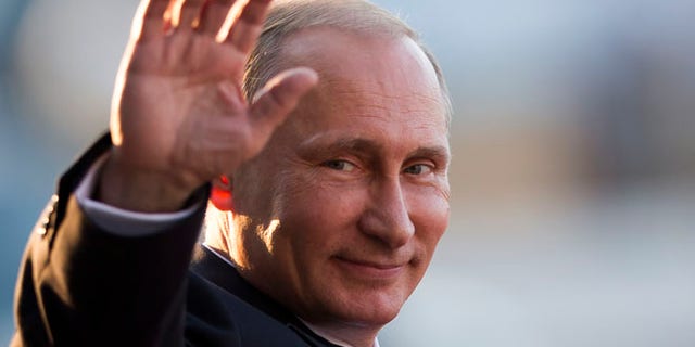July 16, 2014: Russia's President Vladimir Putin waves to photographers as he leaves the Itamaraty Palace after attending the final day of the BRICS Summit in Brasilia, Brazil. (AP)