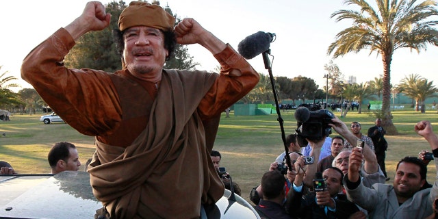 April 10, 2011: Libyan leader Moammar Qaddafi waves at his supporters people in Tripoli