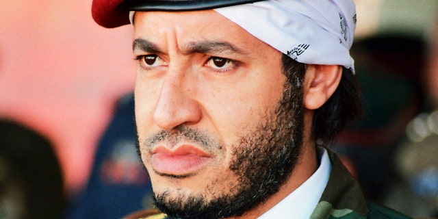FILE - In this undated photo made available Sunday, Sept. 25, 2011, al-Saadi Gadhafi, son of Libyan leader Muammar Qaddafi, watches a military exercise by the elite military unit commanded by his brother, Khamis, in Zlitan - 90 miles southeast of Tripoli, Libya. Muammar Qaddafi's son, al-Saadi, has denied allegations of corruption and intimidation and says an Interpol decision to put him on the equivalent of its most-wanted list is political.