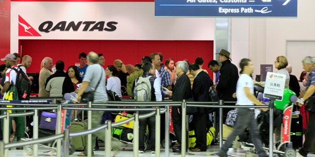 Oct. 29: Travelers gather at the Qantas sales desk at Sydney Airport in Sydney.