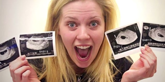 A shocked and ecstatic Ashley Garnder holds up four sonogram photos showing her four babies.