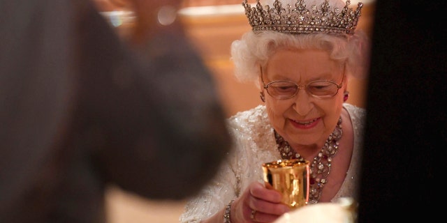 Britain's Queen Elizabeth raises her glass during speeches at The Queen's Dinner, during the Commonwealth Heads of Government Meeting at Buckingham Palace in London, Thursday, April 19, 2018. (Toby Melville/Pool Photo via AP)