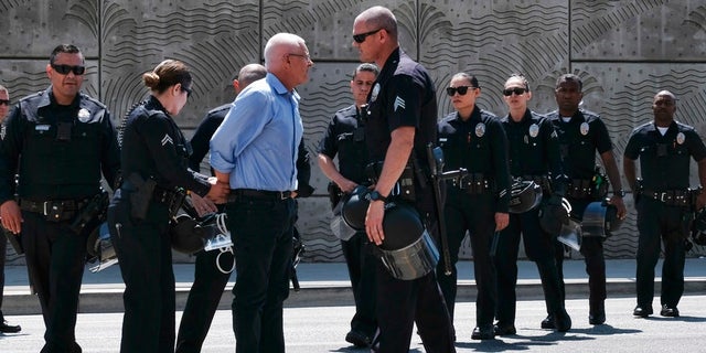 LA City Councilman Mike Bonin is handcuffed after being arrested for blocking entrance to a downtown ICE facility.