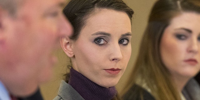 Rachael Denhollander, center, listens to her attorney John Manly speak during a press conference after Michigan sports doctor Larry Nassar was sentenced to 60 years in prison on child pornography charges in Grand Rapids, Mich., on Thursday, Dec. 7, 2017. Denhollander is one of many former patients of Nassar who have accused him of molestation.