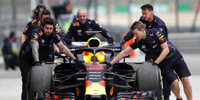 The car of Red Bull driver Daniel Ricciardo of Australia is pushed back to his team's garage after an engine trouble during the third practice session for the Chinese Formula One Grand Prix at the Shanghai International Circuit in Shanghai, Saturday, April 14, 2018.