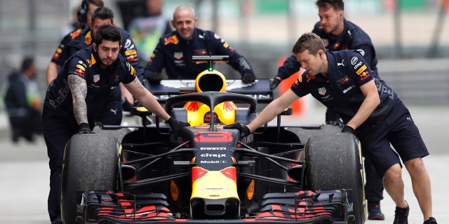 The car of Red Bull driver Daniel Ricciardo of Australia is pushed back to his team's garage after an engine trouble during the third practice session for the Chinese Formula One Grand Prix at the Shanghai International Circuit in Shanghai, Saturday, April 14, 2018.