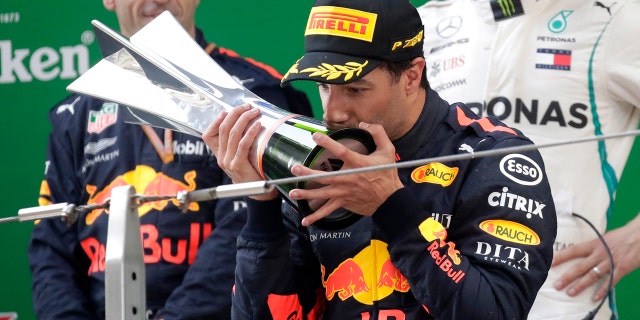 Red Bull driver Daniel Ricciardo of Australia kisses his trophy as he celebrates after winning the Chinese Formula One Grand Prix at the Shanghai International Circuit in Shanghai, Sunday, April 15, 2018.